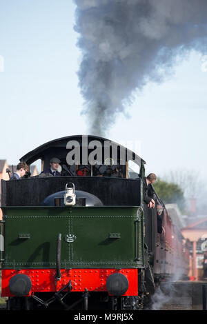 Portrait shot: rear view (tender first) of preserved manor class steam locomotive awaiting departure; crew gets ready for first Sunday morning ride. Stock Photo