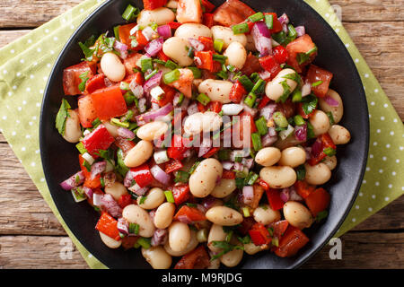 Turkish Bean Salad Piyaz with tomatoes, onions, peppers and cilantro close-up on a plate. horizontal top view from above Stock Photo