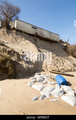 March 2018, Clifftop property collapsing due to coastal erosion after recent storm force winds, Hemsby, Norfolk, England, UK Stock Photo