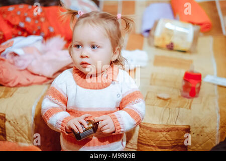 a little girl in a blouse with tails is at home Stock Photo