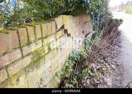 Impact damage to red brick garden wall caused by vehicle reversing, Suffolk, England, UK Stock Photo