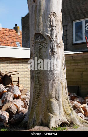 a tree trunk in which animals are cut out Stock Photo