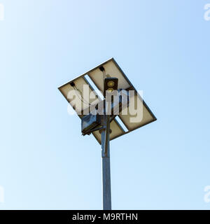 Road lamp with small solar panel on blue sky background. Stock Photo