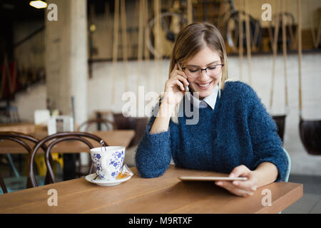 Portrait of busy businesswoman in coffee shop