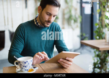 Portrait of young attractive man using tablet Stock Photo