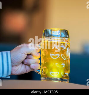 Men Hand with glass mug of golden Freshly filled beer. Real scene in bar, pub. Beer culture, Craft brewery, uniqueness beer grades, meeting of low alcohol beverage lovers Stock Photo