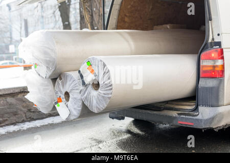 Carpet delivery van with open trunk. Large bulky cargo transportation. Carpeting sale and delivery concept Stock Photo