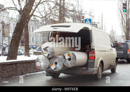 Carpet delivery van with open trunk. Large bulky cargo transportation. Carpeting cleaning and delivery concept Stock Photo