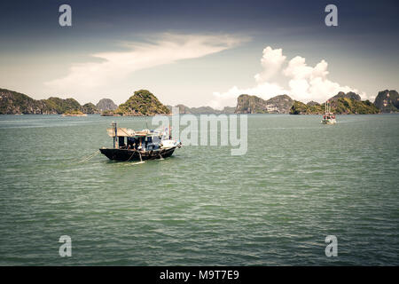 cruising among beautiful limestone rocks and secluded beaches in Ha Long bay, UNESCO world heritage site, Vietnam Stock Photo