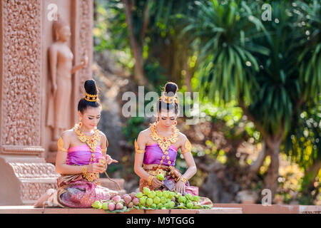 Kanchanaburi, Thailand - December 14, 2014: Women with traditional dresses folding lotus petal for being used to worship Buddha image in Buddhist chur Stock Photo