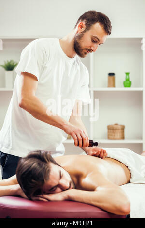 Young man is enjoying massage on spa treatment. Stock Photo