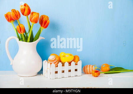 Easter still life with Easter eggs and tulips. Easter eggs in a white box.  Easter greeting card. Stock Photo