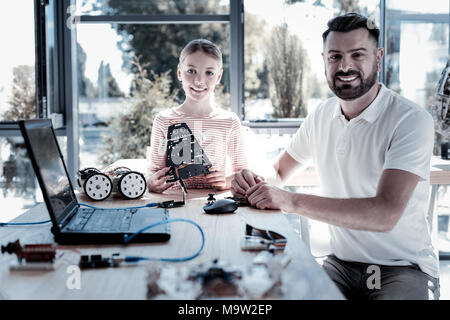 Smiling girl and teacher smiling while spending time in workshop Stock Photo