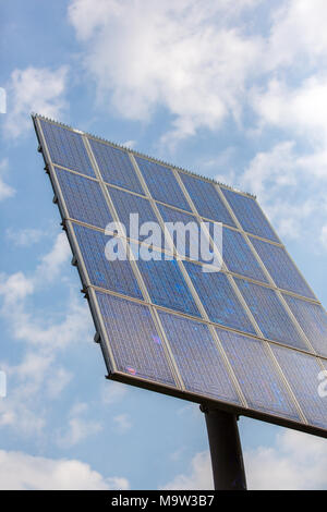 Pole with 20 solar panels collecting sunlight in a blue sky. Stock Photo