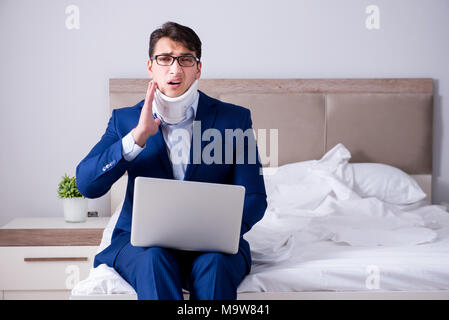 Businessman with neck injury working from home Stock Photo