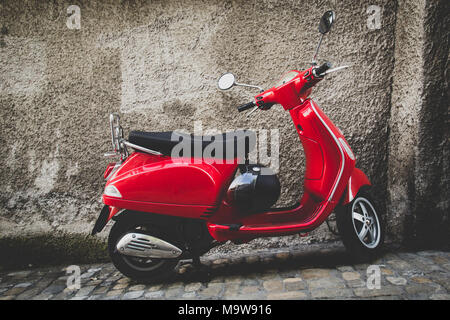 Vintage red scooter parked in front of a grey wall in Thun Switzerland Stock Photo