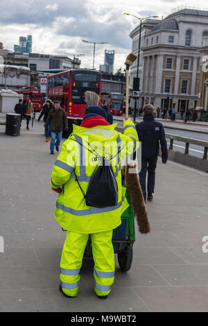 a street cleaner in central london on the bridge in southwark. working man keeping the streets of the capital city clean and free from litter and tat. Stock Photo