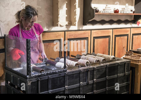 PRAGUE, CZECH REPUBLIC - 02 MAY 2015: The preparation of the national Czech sweet dishes - trdelnik near Staromesskoy Square on May 2, 2015. Stock Photo