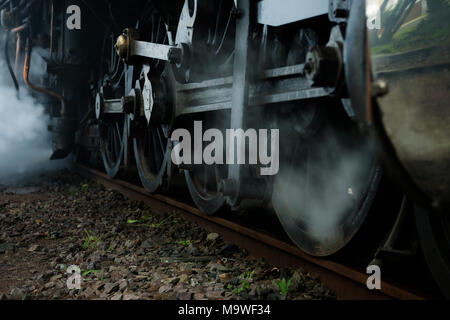 Close-up, steam discharge, mechanical detail of vintage steam train, engine, wheels, working, locomotive Stock Photo