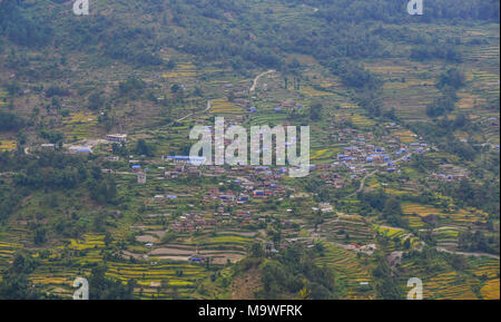 The mountain village with rice fields in Nepal located on cascades and surrounded by greenery. Stock Photo