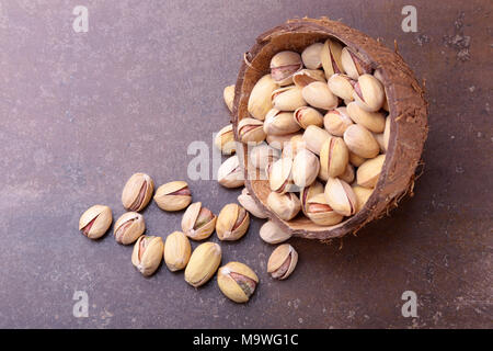 handmade bowl of coconut with pistachios on a stone table. Close-up Stock Photo