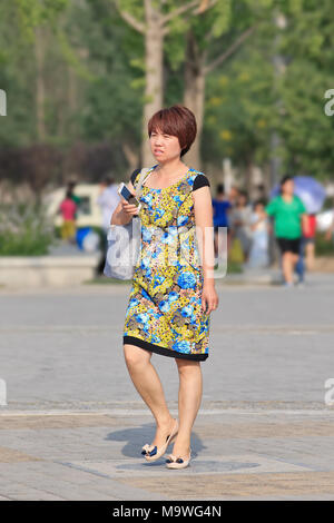 BEIJING-JUNE 20, 2015. Middle-aged Chinese woman walks in Niantan Park, the biggest in the city. Stock Photo