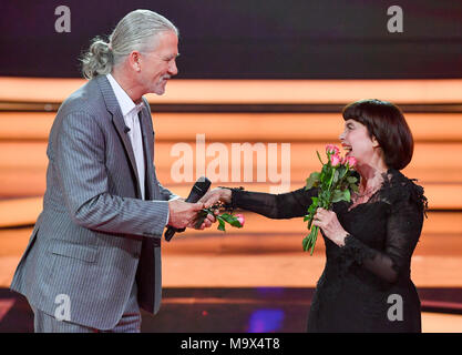 24 March 2018, Germany, Hof: Mireille Mathieu and Patrick Duffy singing together at the gala 'Willkommen bei Carmen Nebel' (lit. Welcome to Carmen Nebel) on the ZDF channel. Photo: Jens Kalaene/dpa Stock Photo