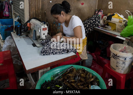 Siem Reap, Cambodia, 28 March 2018. Siem Reap, Cambodia, 28 March 2018. Cambodian girl repairing a cloth with her sewing machine at the Fresh Food Market Credit: David GABIS/Alamy Live News Stock Photo