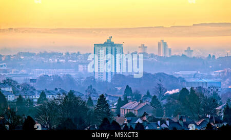 Glasgow, Scotland, UK 29th March 2018. UK Weather: Freezing morning with fog and mist causes a spectacular dawn and fog picturesque start over the city.The rooftops of the suburb of Knightswood covered in early morning frost contrast with the towers of the south of the city with the hills hidden and stratified by the rising early morning mist. Gerard Ferry/Alamy news Credit: gerard ferry/Alamy Live News Stock Photo