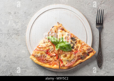 Two piece of Italian pizza with tomatoes mushrooms bacon and che Stock Photo