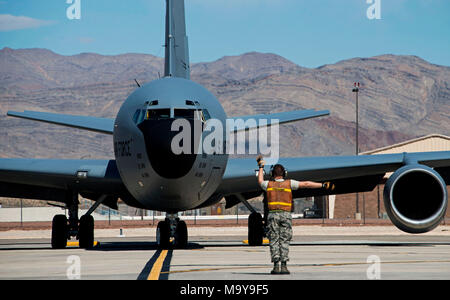 A 92nd Aircraft Maintenance Squadron crew chief marshals a KC-135 Stratotanker on the flight line during Red Flag 18-2 at Nellis Air Force Base, Nevada, March 12, 2018. Red Flag is a realistic combat training exercise involving air, space and cyber forces of the U.S. and its allies. It provides pilots with training using real-time war scenarios. (U.S. Air Force photo/Senior Airman Janelle Patiño) Stock Photo