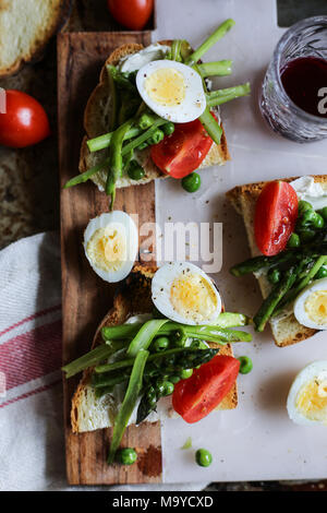 Quail eggs, peas and asparagus crostini Stock Photo