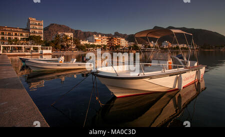 Small boats at sunrise at Porto Pollenca on the Mediterranean coast of Mallorca, Spain Stock Photo