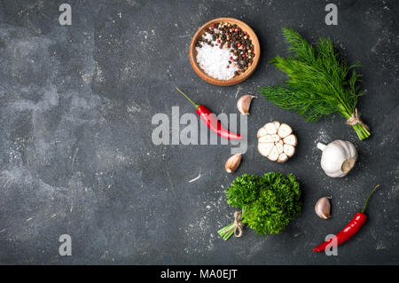Herbs and spices cooking on stone table. Parsley, dill, garlic and pepper. Seasoning ingredients for cooking. Top view with copyspace Stock Photo