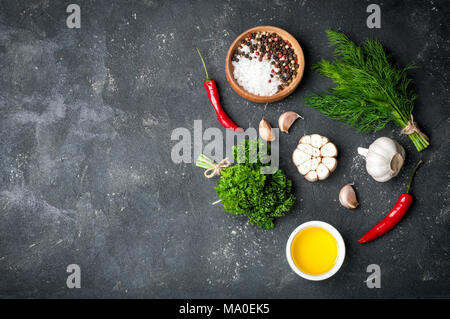 Herbs and spices cooking on stone table. Parsley, dill, garlic and pepper. Seasoning ingredients for cooking. Top view with copyspace Stock Photo