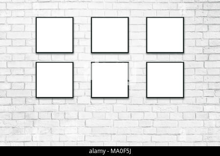 Blank white paper poster in black frame at white paint brick wall. Grungy interior, poster mock up. Presentation for artwork. Stock Photo