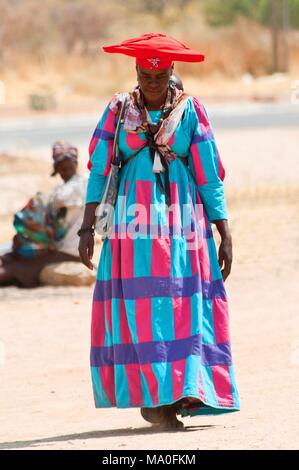 Herero woman in traditional dress and horned hat, Kaokoland wilderness region, Namibia, Africa. Stock Photo