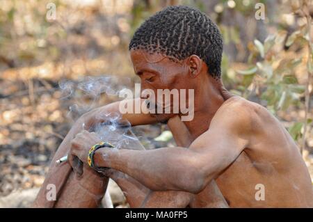 Bushman (San) man smoking cigarette in the Kalahari desert in Ghanzi, Botswana. Stock Photo