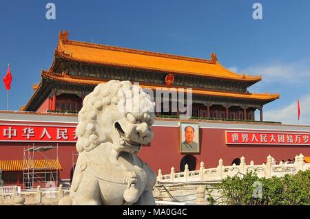 A Lion Statue Guarding The Entrance to the Forbidden City with a portrait of Mao Zedong in the background in Tiananmen Square Beijing China. Stock Photo
