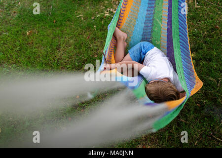 Young boy relaxing on hammock Stock Photo