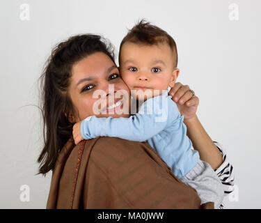 Smiling south asian mother holding her eurasian baby Stock Photo