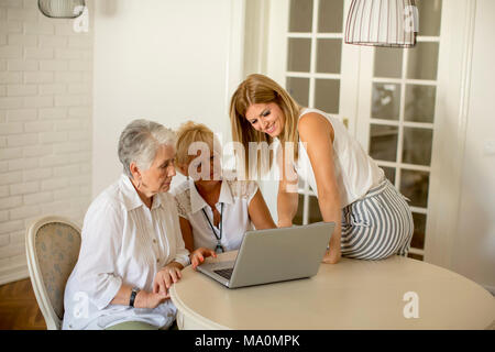 Portrait of happy women of three generations using laptop  in the room at home Stock Photo