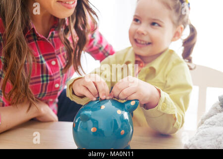 Young mother teaches her daughter to save money Stock Photo