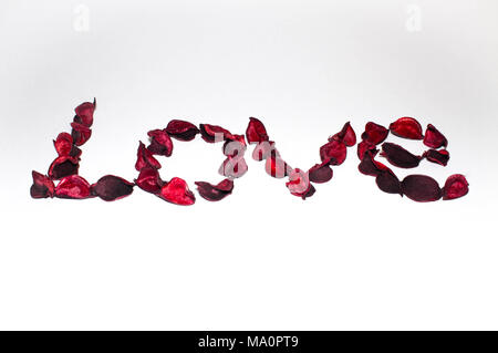 heart and word love laid out from artificial flowers on a white background Stock Photo