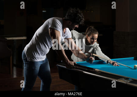 Young Caucasian Woman Receiving Advice On Shooting Pool Ball While Playing Billiards Stock Photo