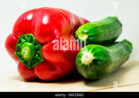 soft focus of fresh red pepper and green zucchini on a white background - capsicum, cocurbita pepo Stock Photo