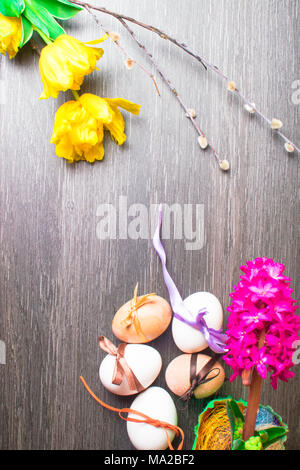 easter eggs decorated with color ribbons and pink geocint and yellow tulips flower, ladybird, willow Stock Photo
