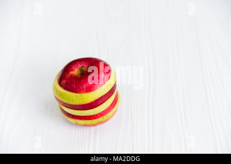 Close up Mixed slices of red and green apple on white wooden surface Stock Photo