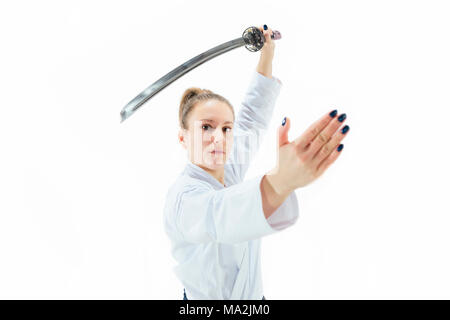 Aikido master practices defense posture. Healthy lifestyle and sports concept. Woman in white kimono on white background. Stock Photo