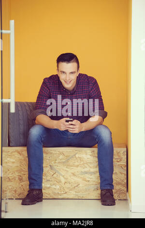 young man in crative box working on smart phone, startup business modern office room  interior Stock Photo